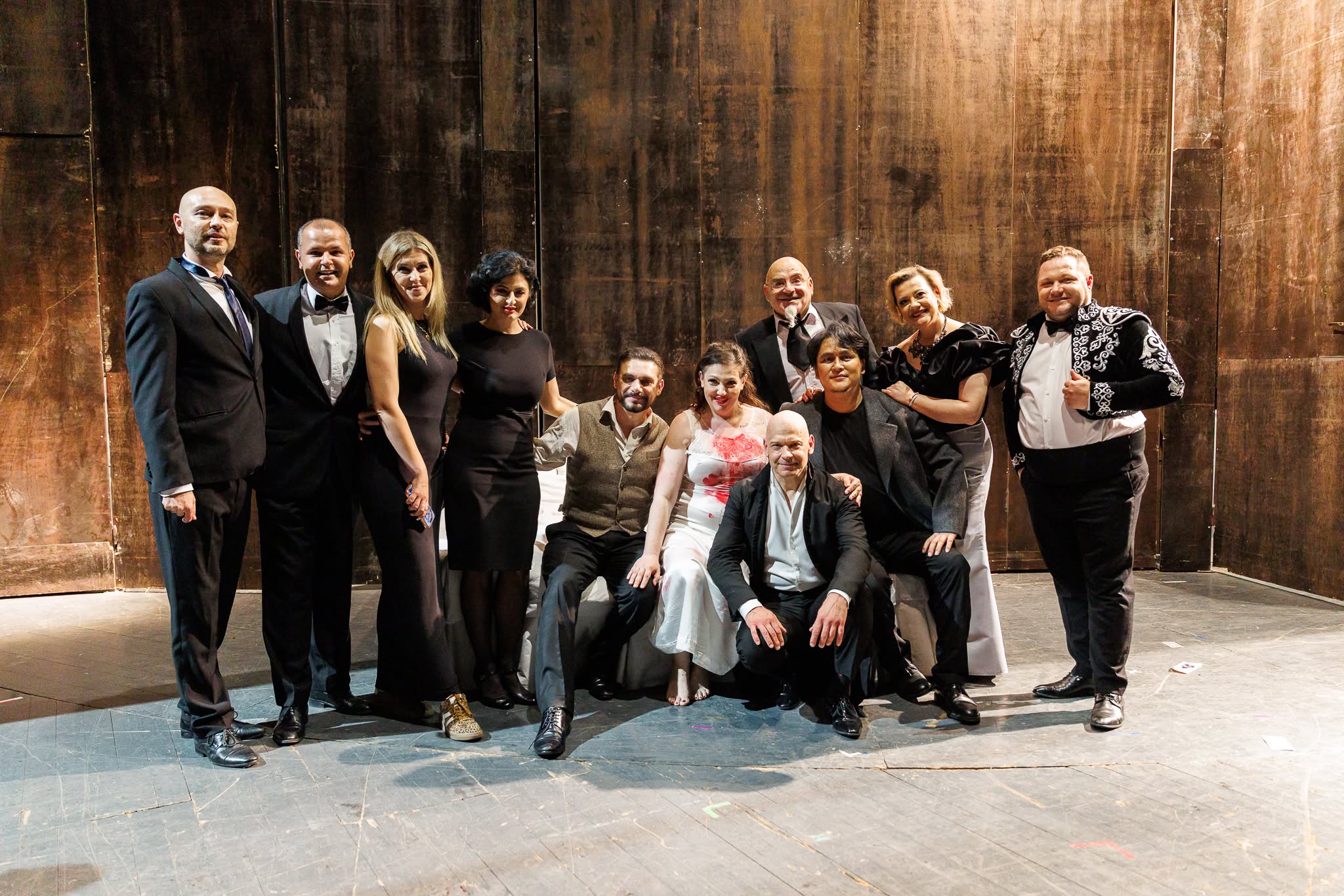 Group of opera cast and crew members posing together on stage after a performance