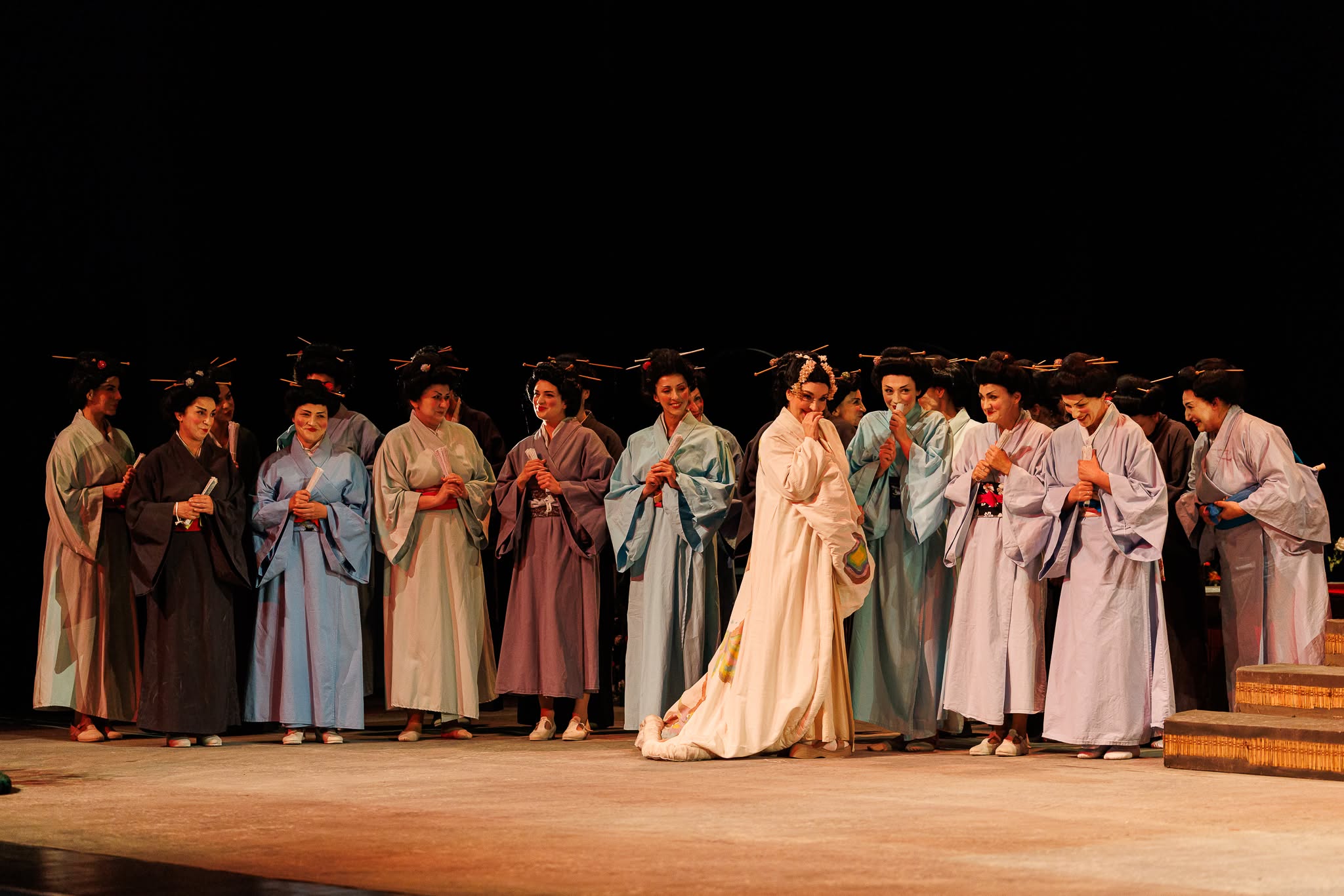 Group of opera singers on stage wearing traditional Japanese kimonos with traditional hair ornaments